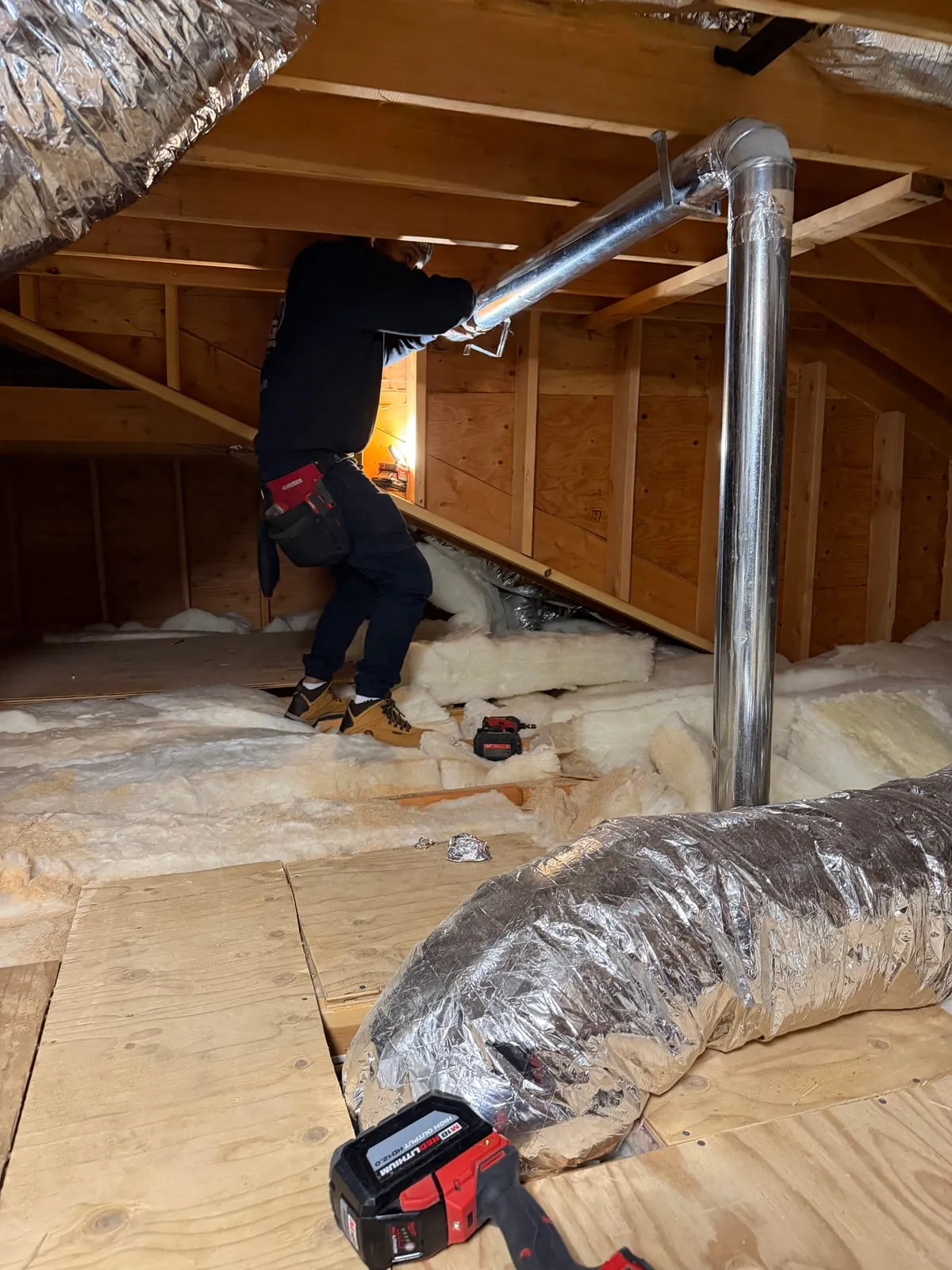 A flexible duct run and its metal riser in an insulated attic